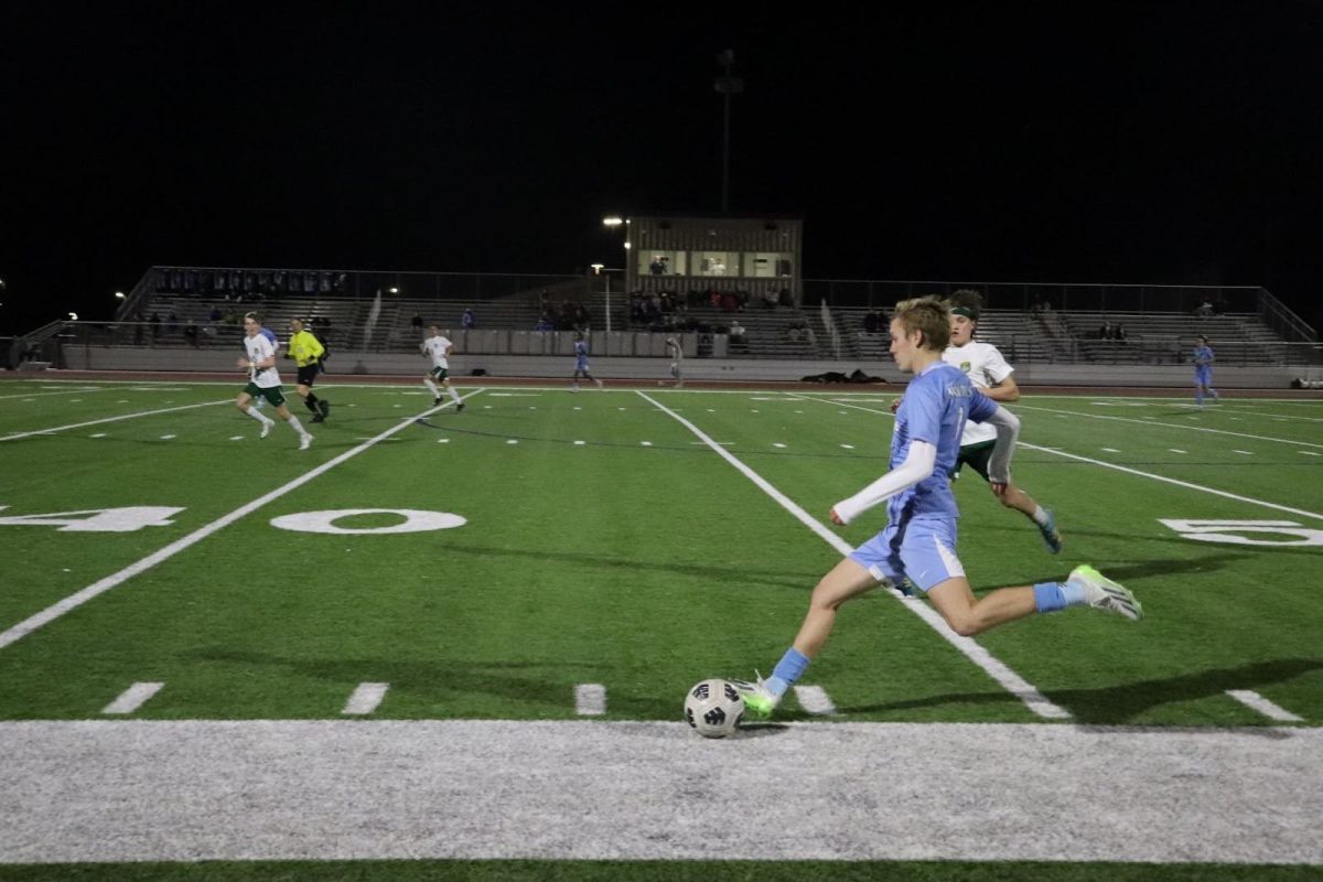 Sophomore Ethan McCullough shoots the ball far to his teammate, seeking a chance to score.