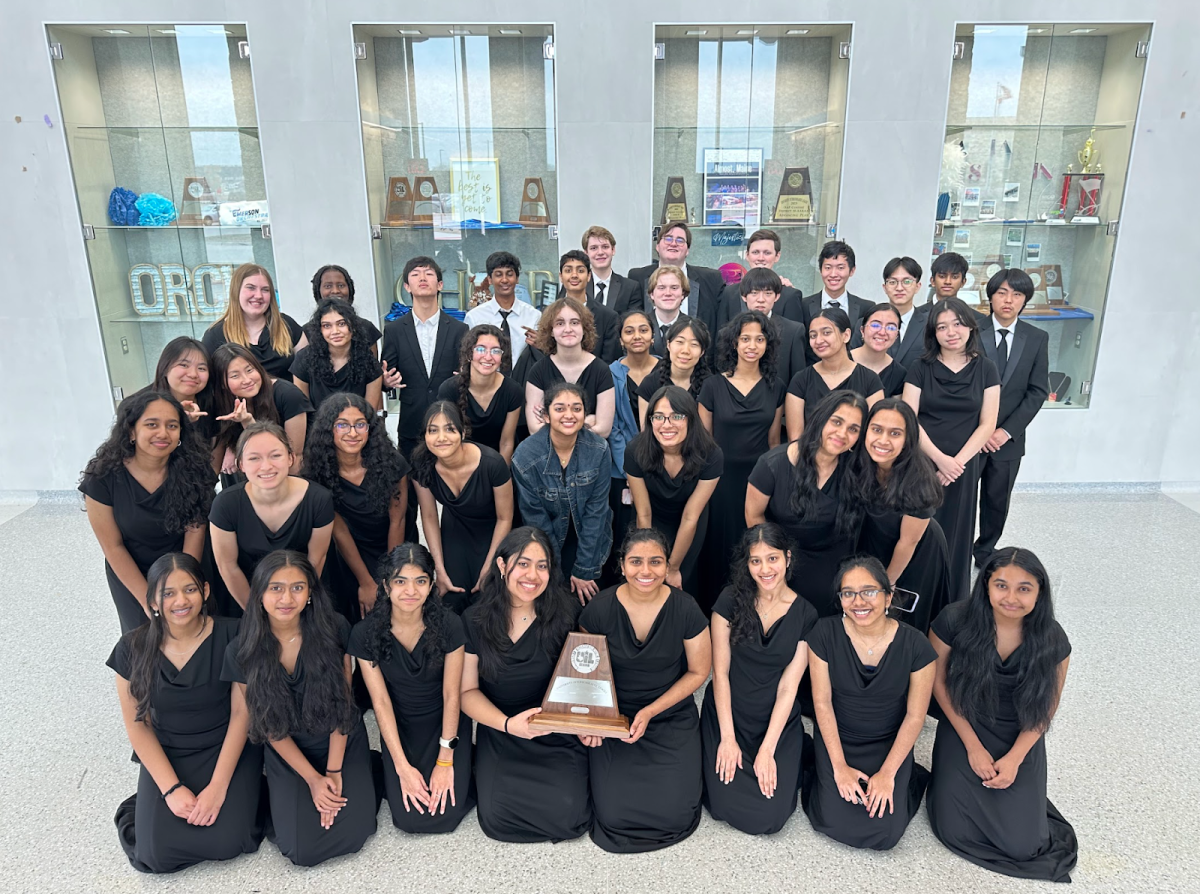 The Philharmonic Orchestra commemorates their win at UIL with a picture holding their trophy.