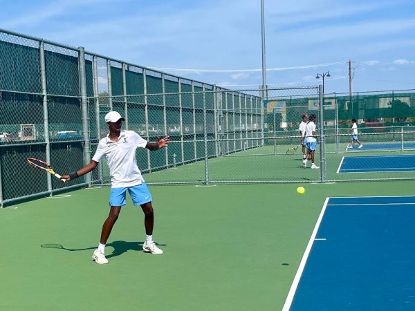 Varsity team captain, Gautam Pangulari, 11, sets up a forehand during a home match.