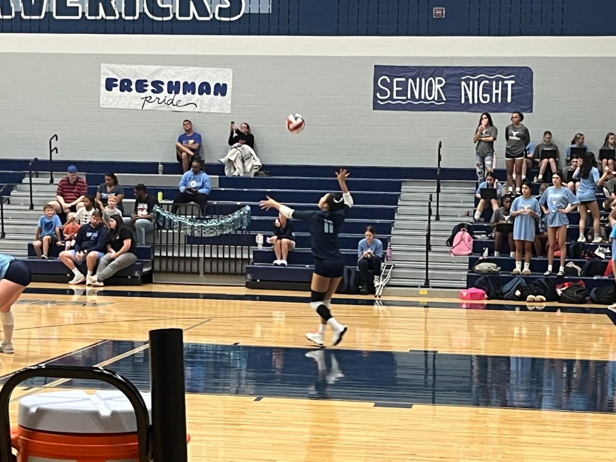 Olivia Kim, 12, serves the ball over the net during the game against Liberty High School. 