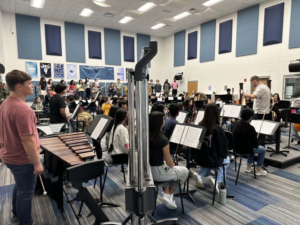 Choir Director Christopher Orr conducts a rehearsal for the Fine Arts Showcase.
