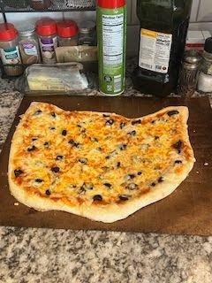 Making a pizza in the shape of a cat captures the Halloween spirit and is an easy alteration to classic foods. 