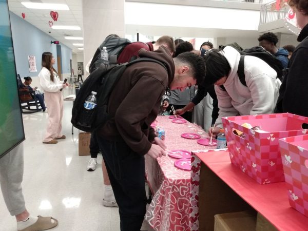 Emerson students compete in a Valentine’s themed race to move as many candy hearts to the other plate using chopsticks before time runs out.