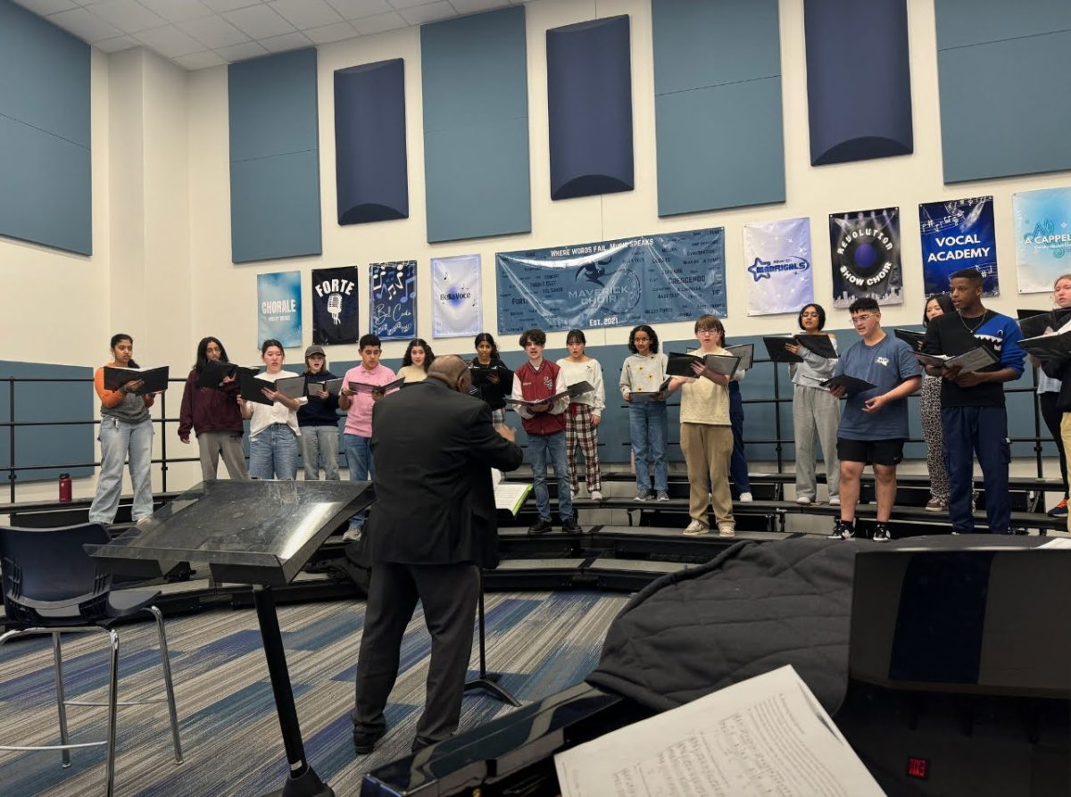 Choir students practice their music with a clinician to prepare for the concert.