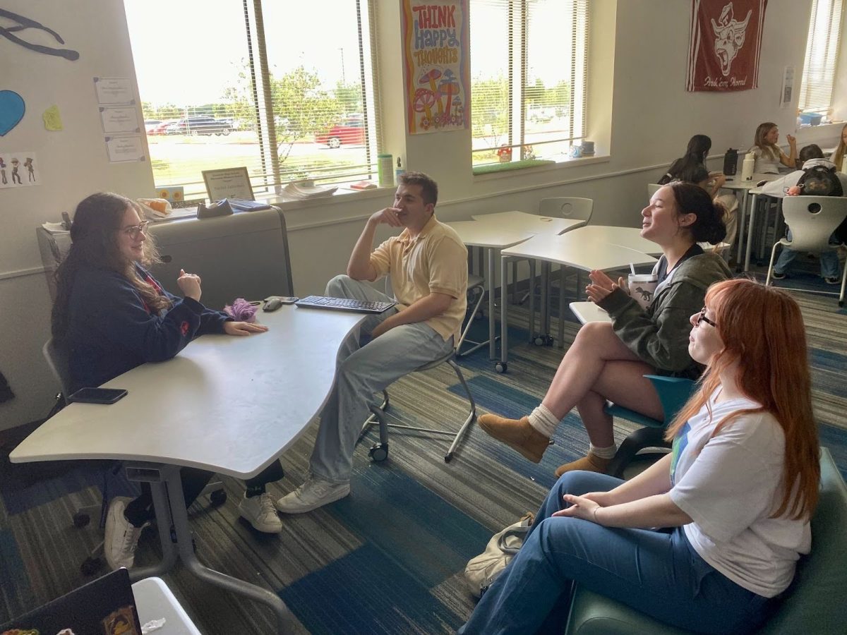 English teacher Rachel Jadormeo bonds with her senior students Brody Kostyszyn, 12, Alexis Alley, 12, and Natalie Castellano, 12, during Power Hour as they discuss a Broadway show they are watching. 