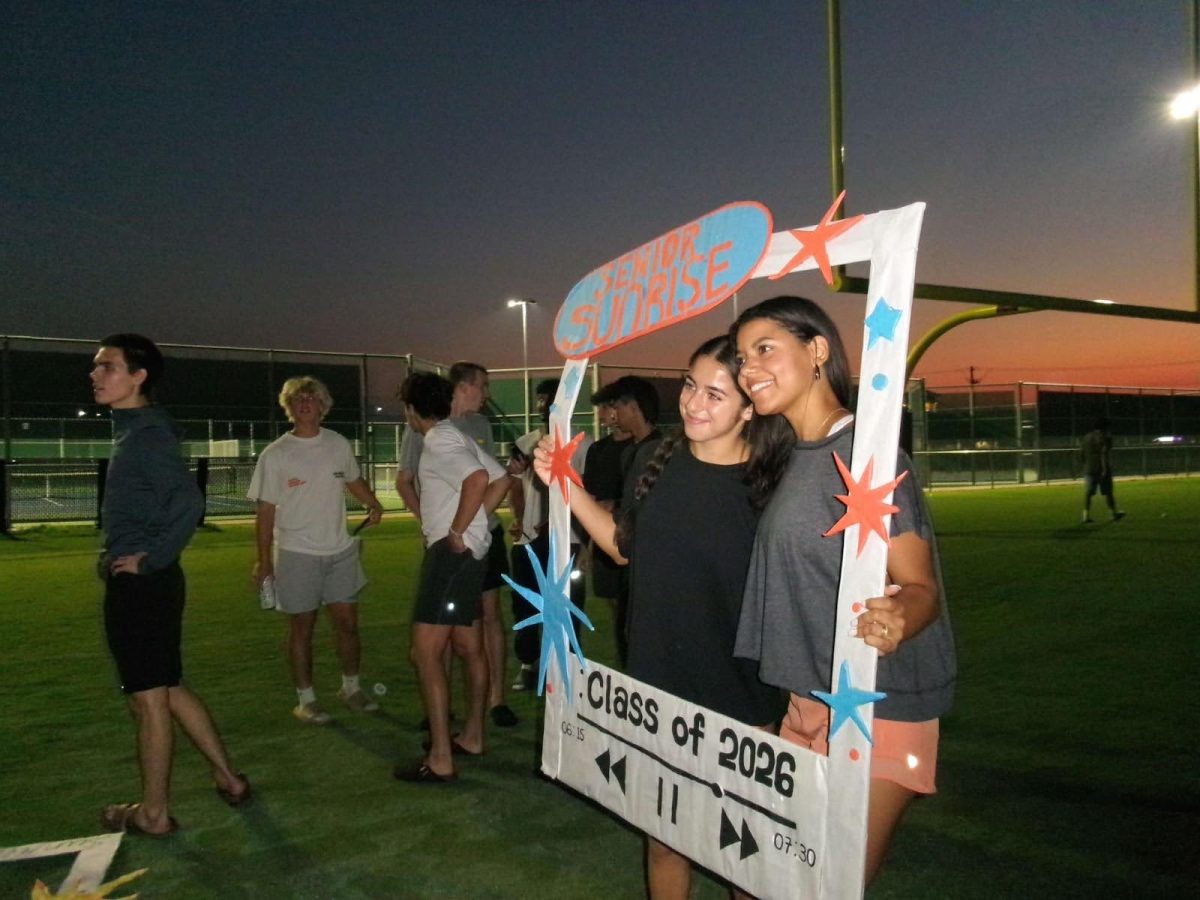 Rebecca Rovner, 12, and Aidyn Guernsey, 12, show off photo-prop while attending Senior Sunrise. 