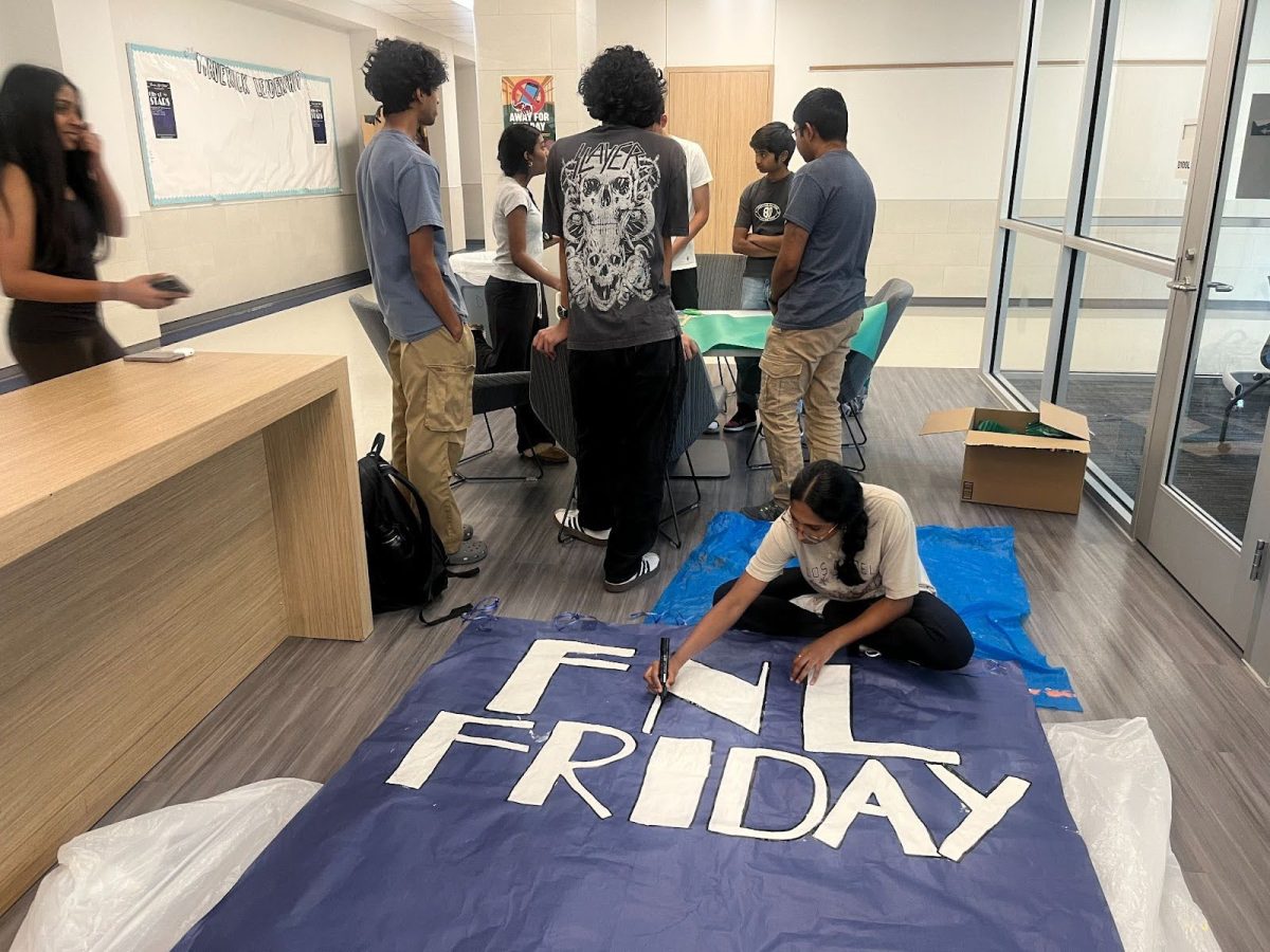 A Maverick Leadership student working on a poster for Homecoming Week