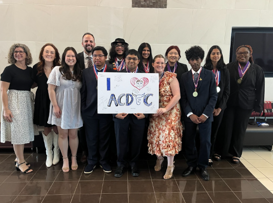 The AcDec team posing with their sign after winning awards.