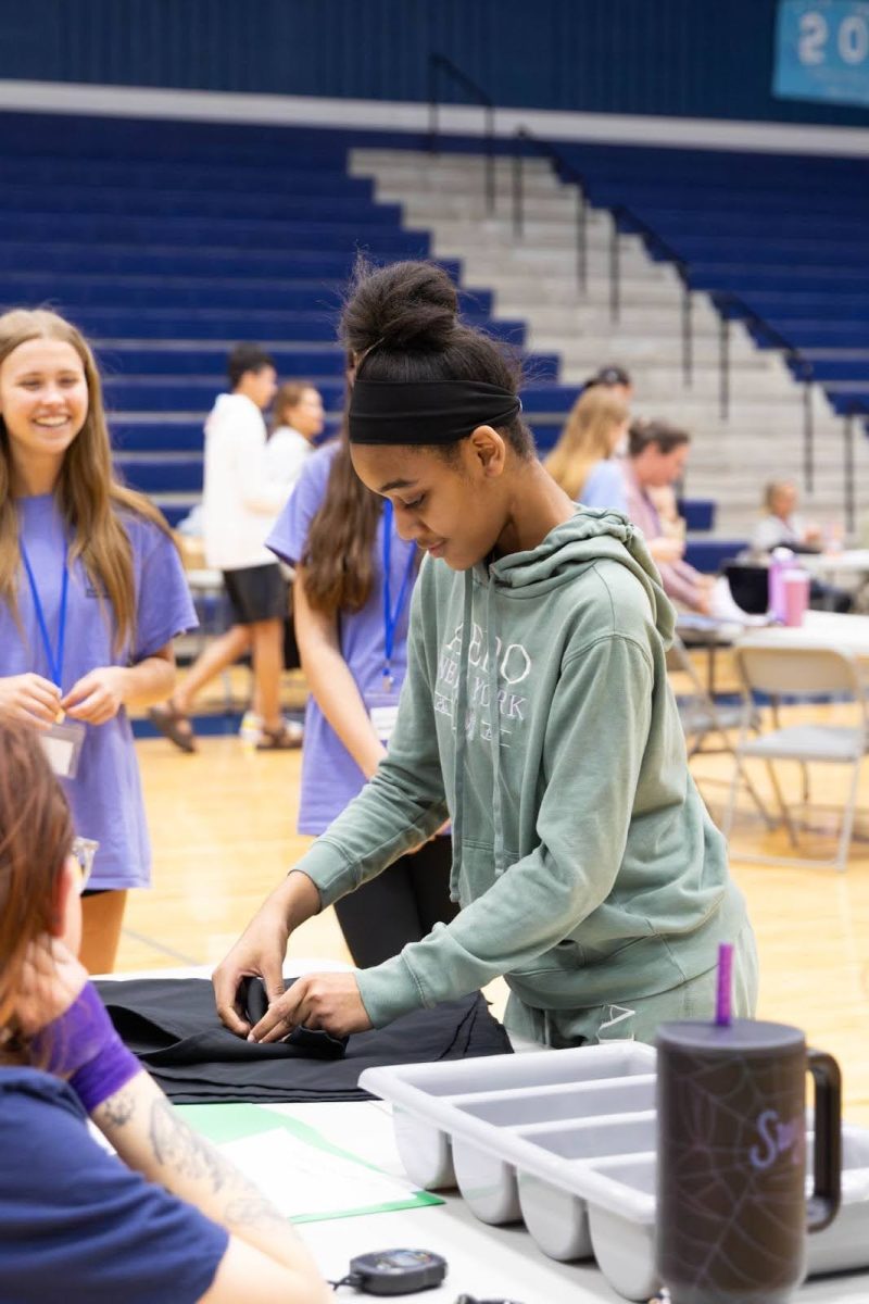 Participants like Kaylee Ashford, 11, showcased their career-oriented skills at the Job Olympics through activities like rolling silverware or folding towels (Jackie Sowa, 12).