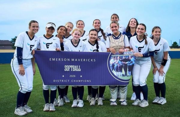 The softball team carries a banner that commemorates their achievement.